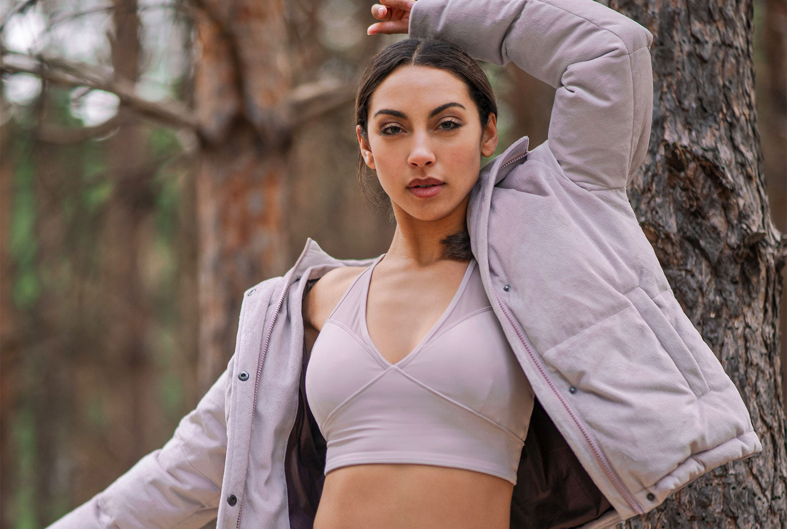 Female model wearing a pink jacket and sports bra
