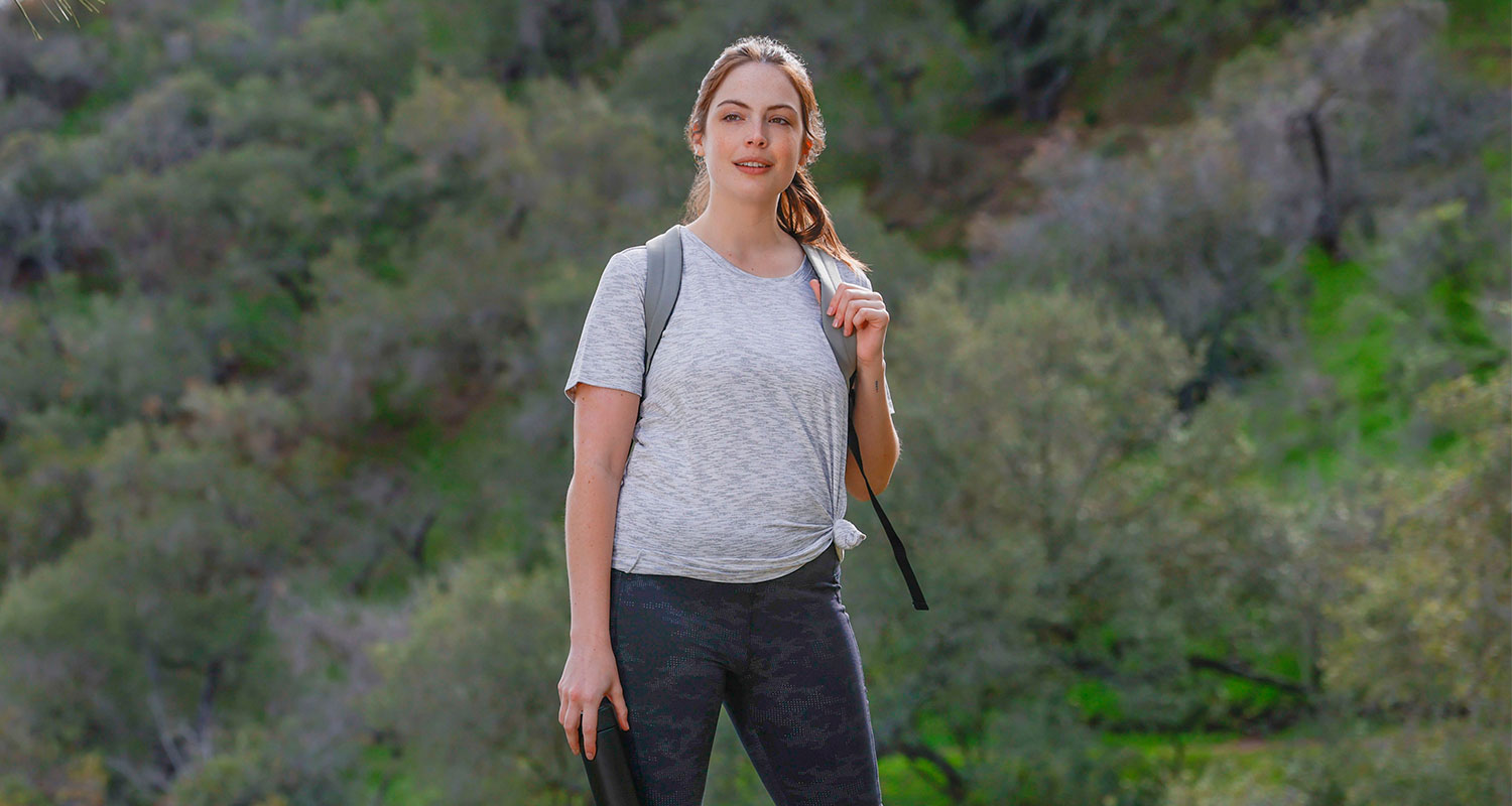 Young female Mondetta model in a grey t-shirt hiking in the hills
