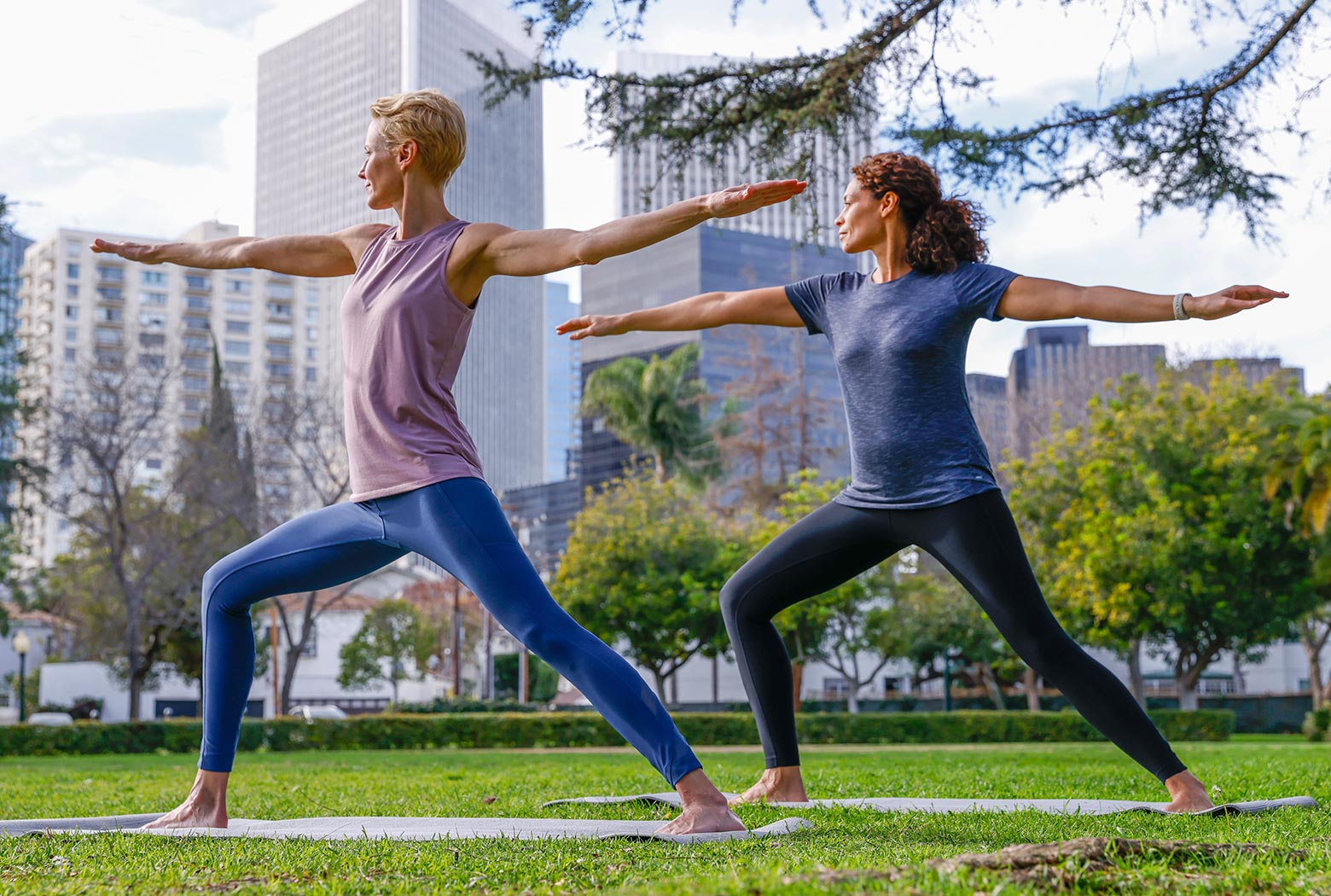 Two mature Mondetta female models practicing yoga in a city park