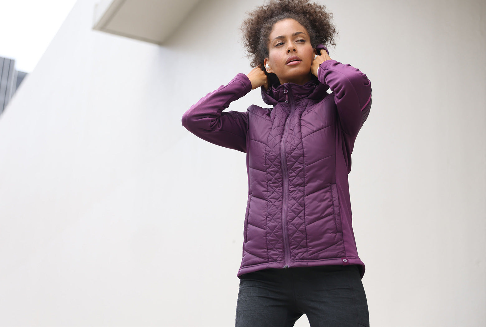 Mondetta female model wearing a purple quilted jacket, wide image